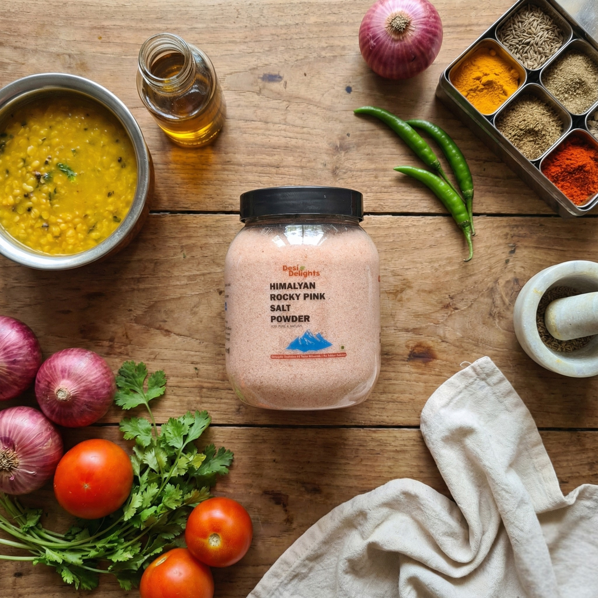 Jar of Himalayan Rock Pink Salt Powder on a wooden table with spices and vegetables
